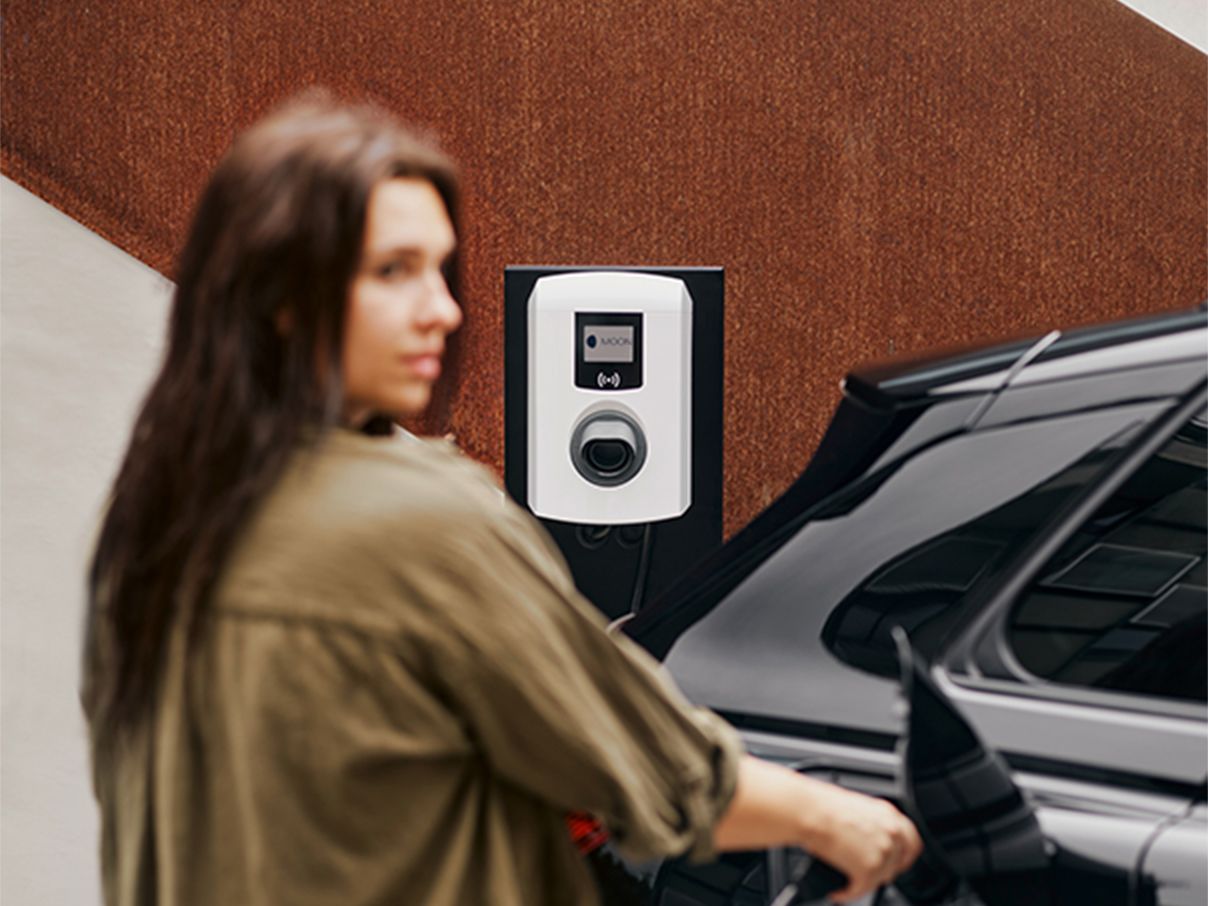 Woman charging electric car with a wallbox