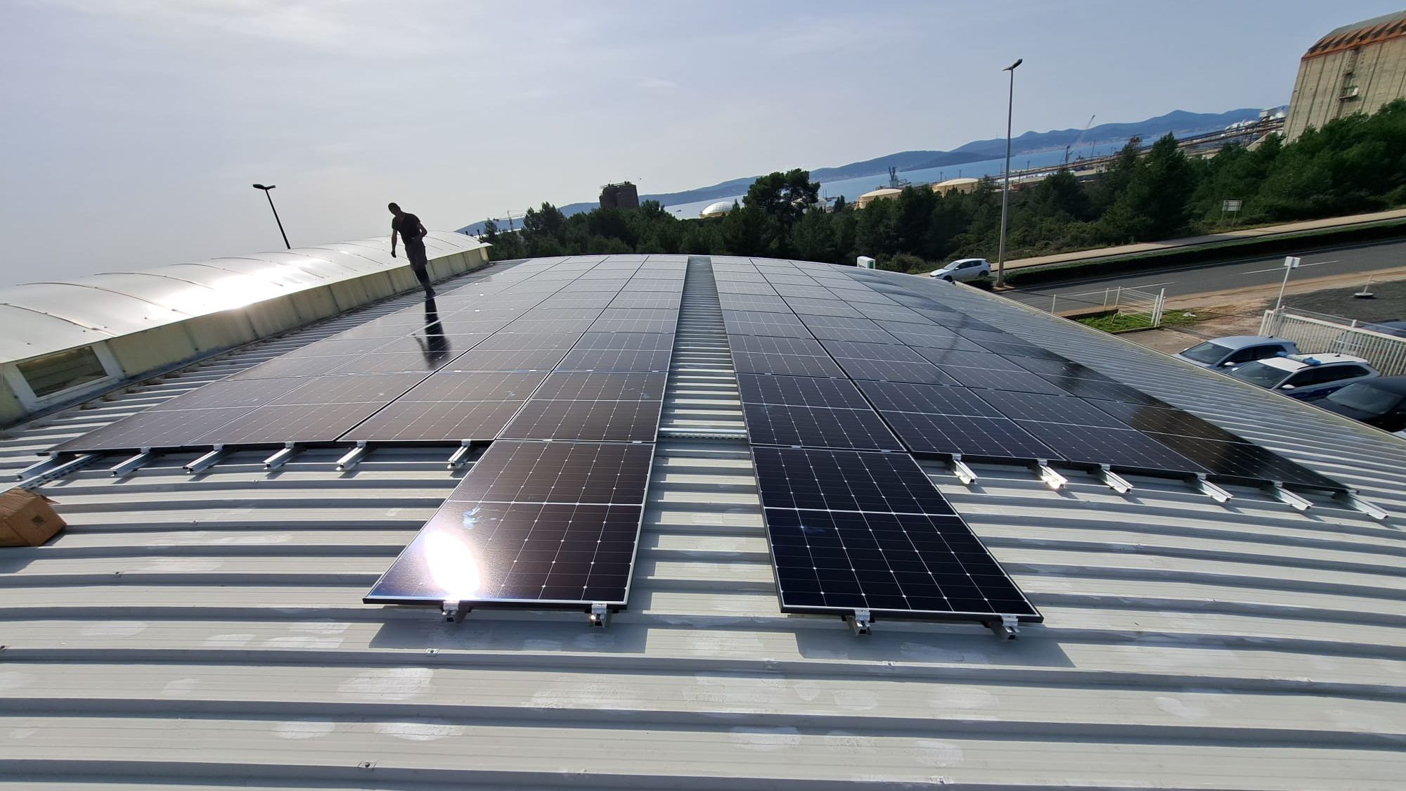 Man walks next to a PV system on top of a roof