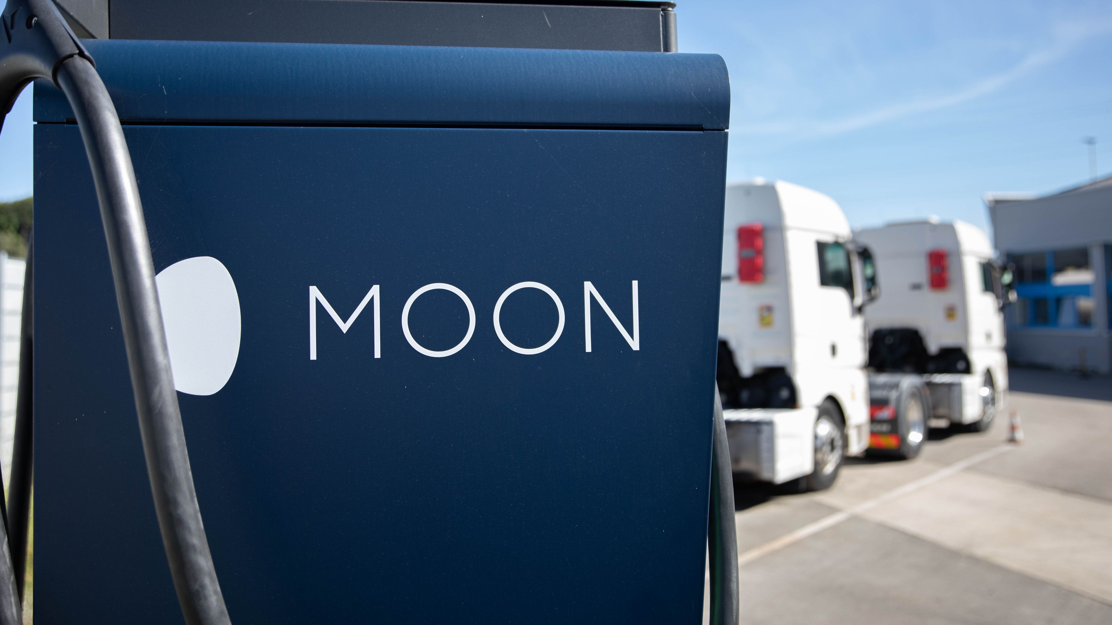 two trucks are parked behind a HYC 200-400 fast charging station