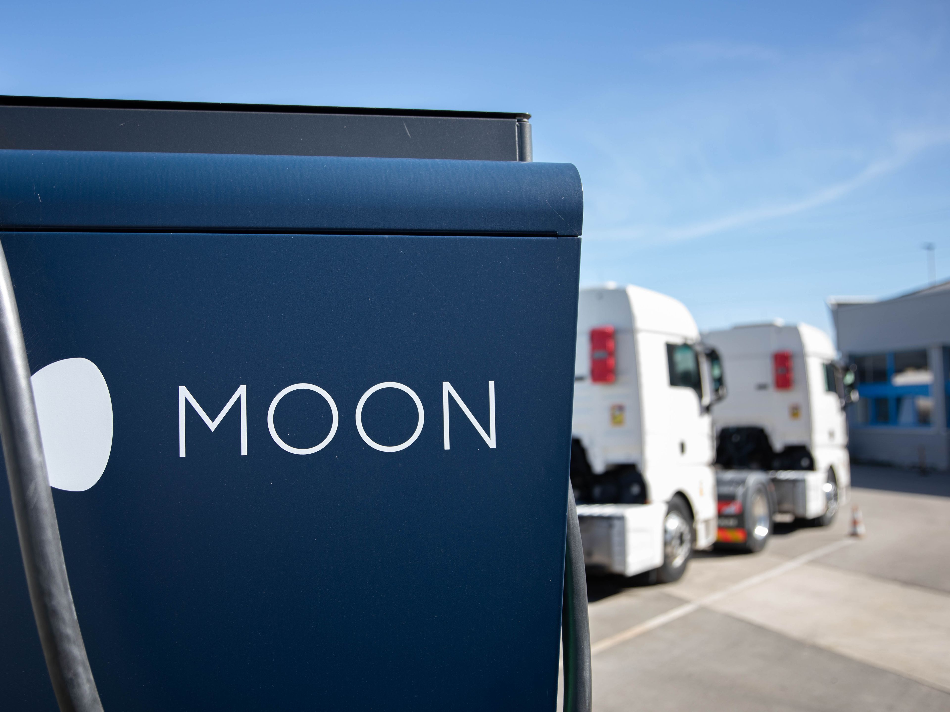 two trucks are parked behind a HYC 200-400 fast charging station