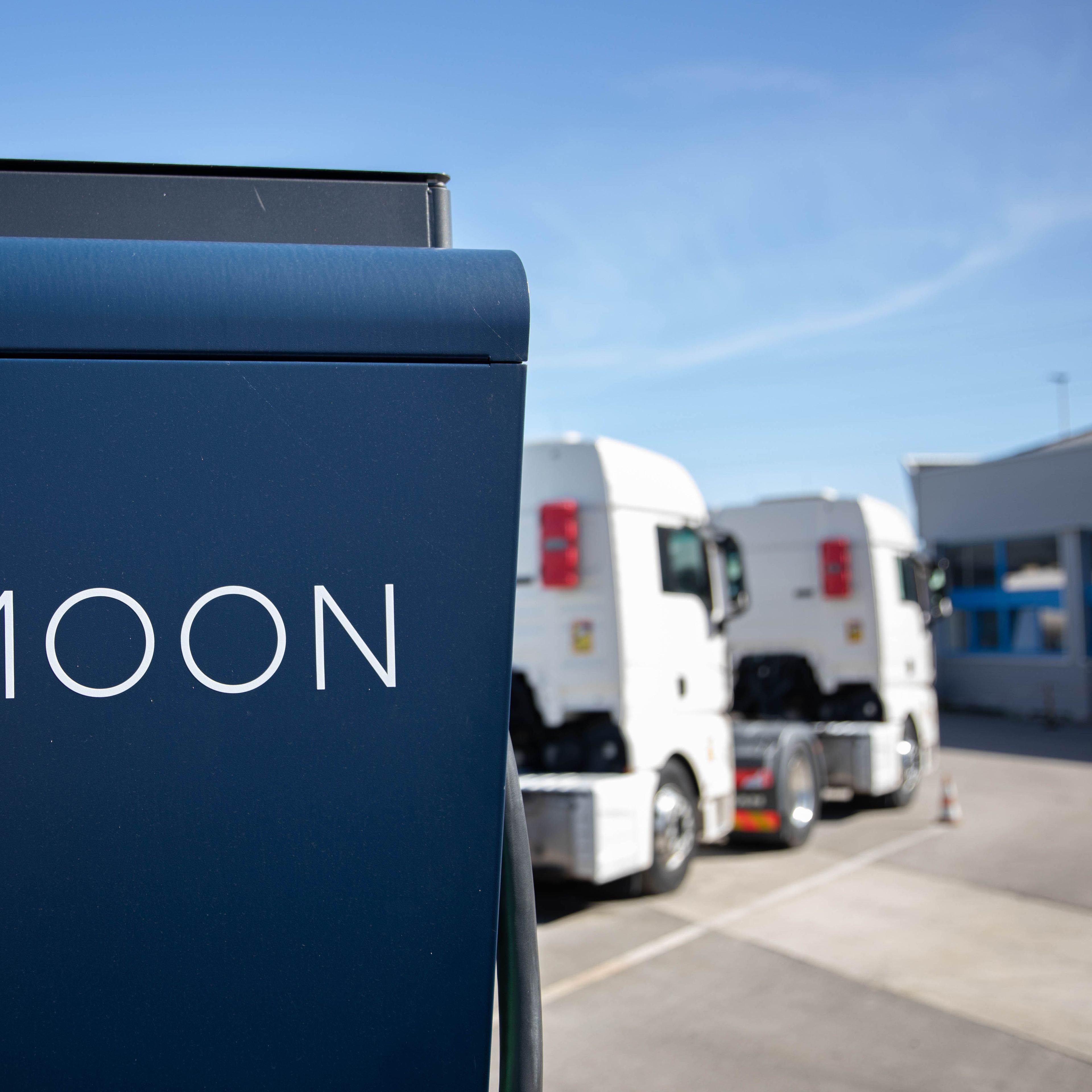 two trucks are parked behind a HYC 200-400 fast charging station