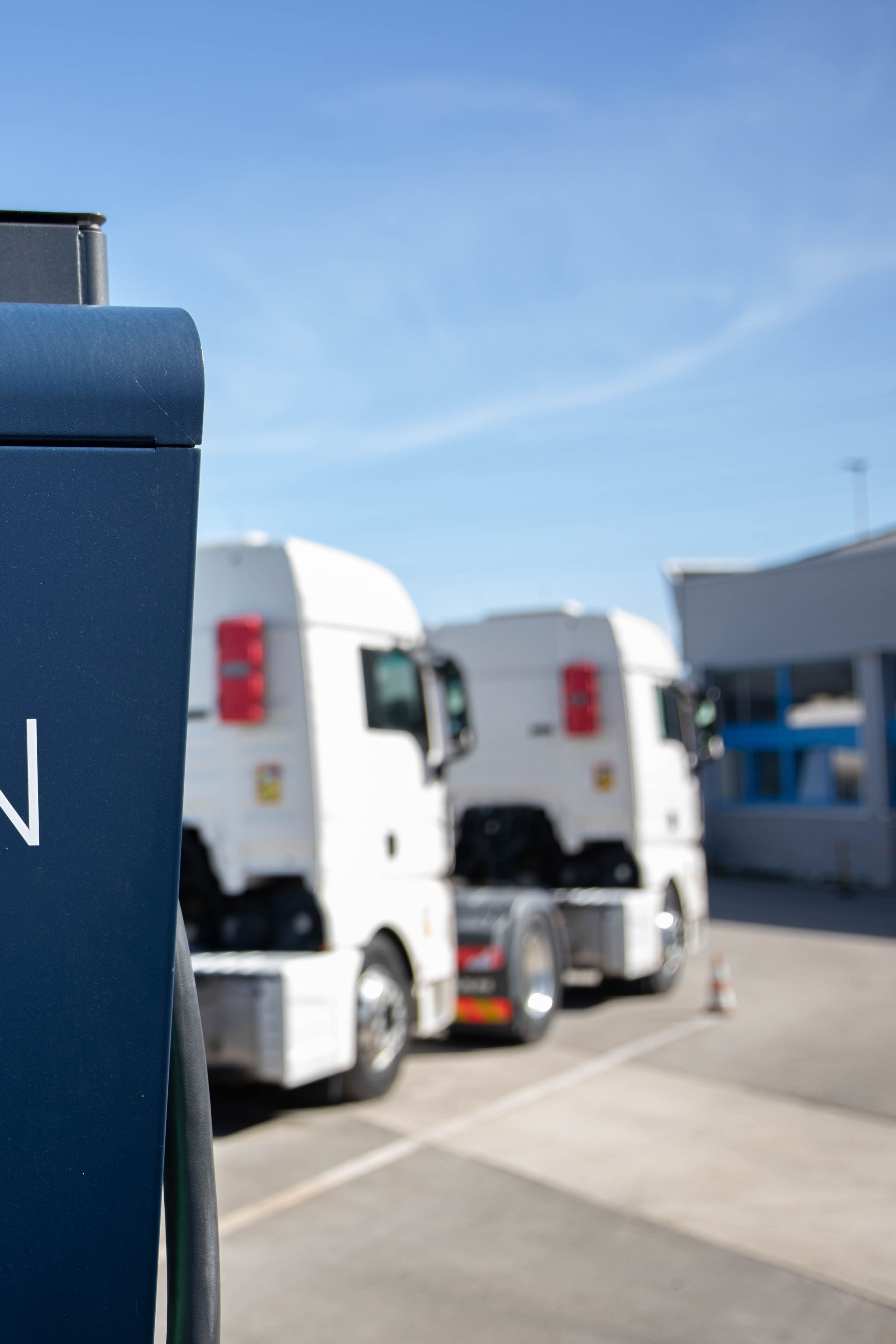 two trucks are parked behind a HYC 200-400 fast charging station