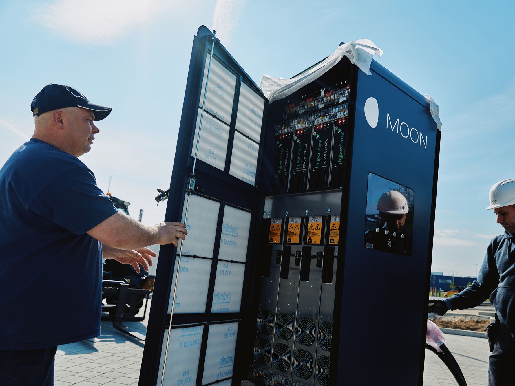 two men carry out the installation of a POWER Charger fast charging station
