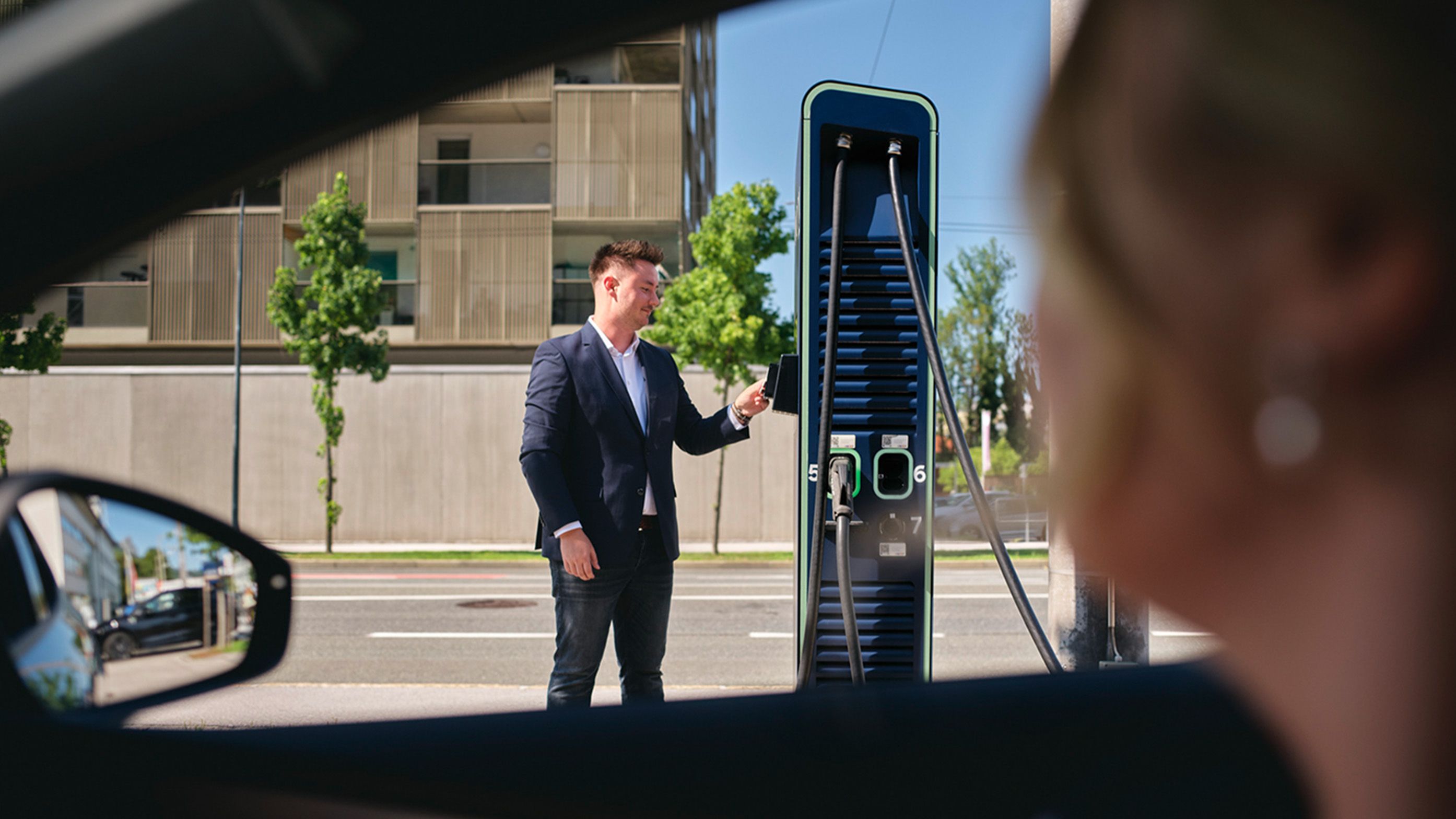 Person holds card to a charging station