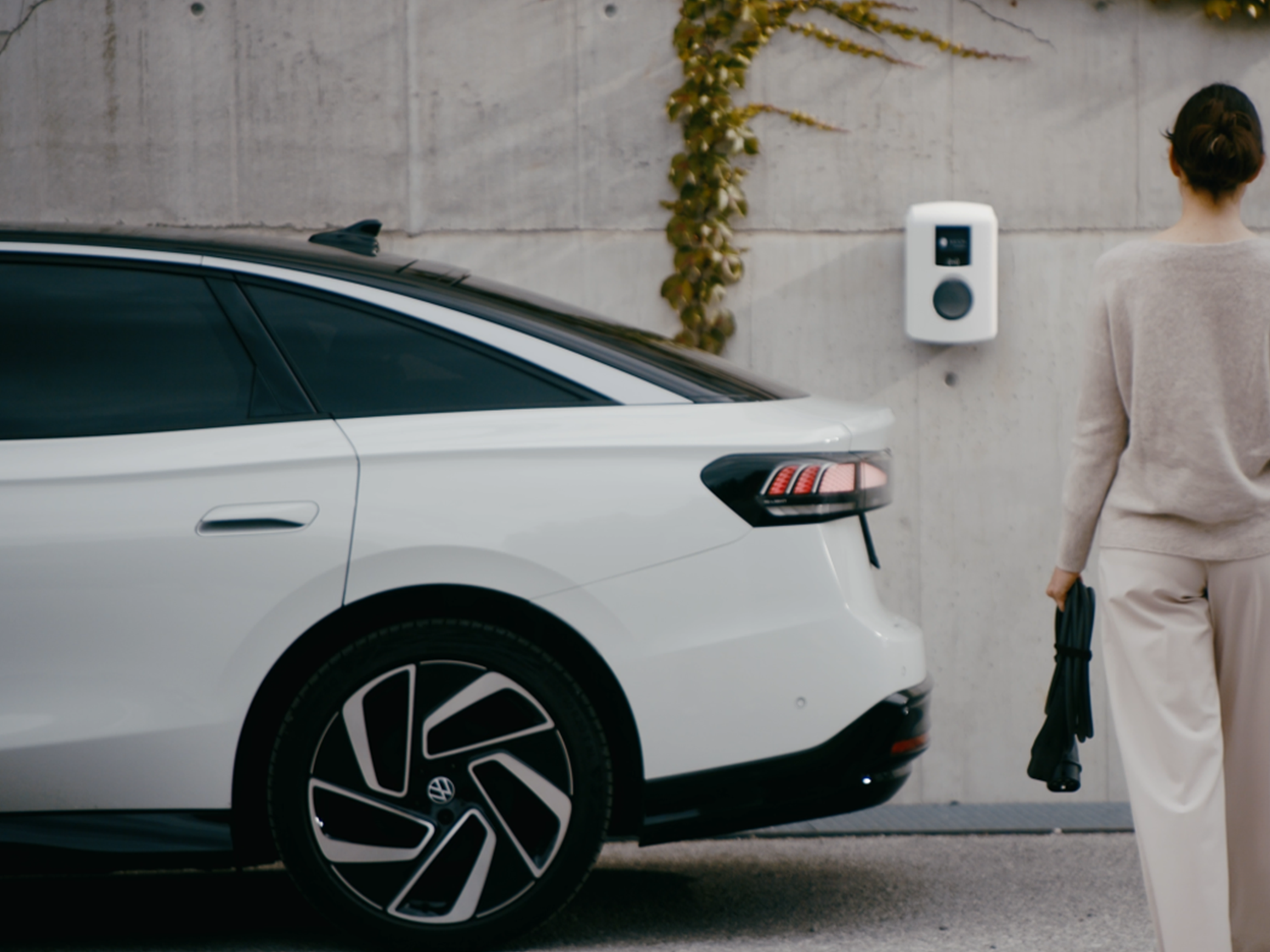 Woman walks towards a charging station on a wall