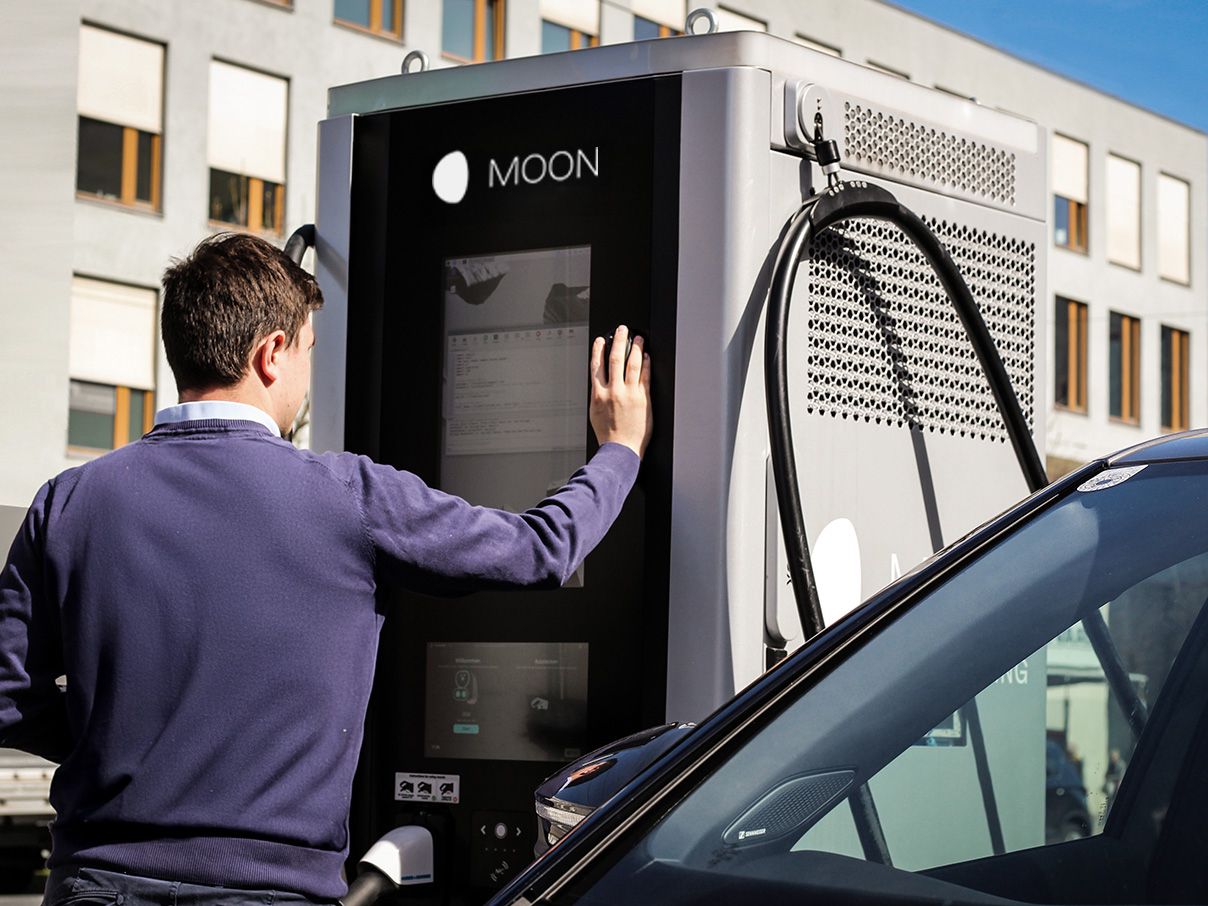 Man operating display of a fast charging station