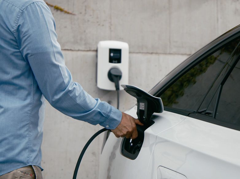 Person charging electric car at a wallbox