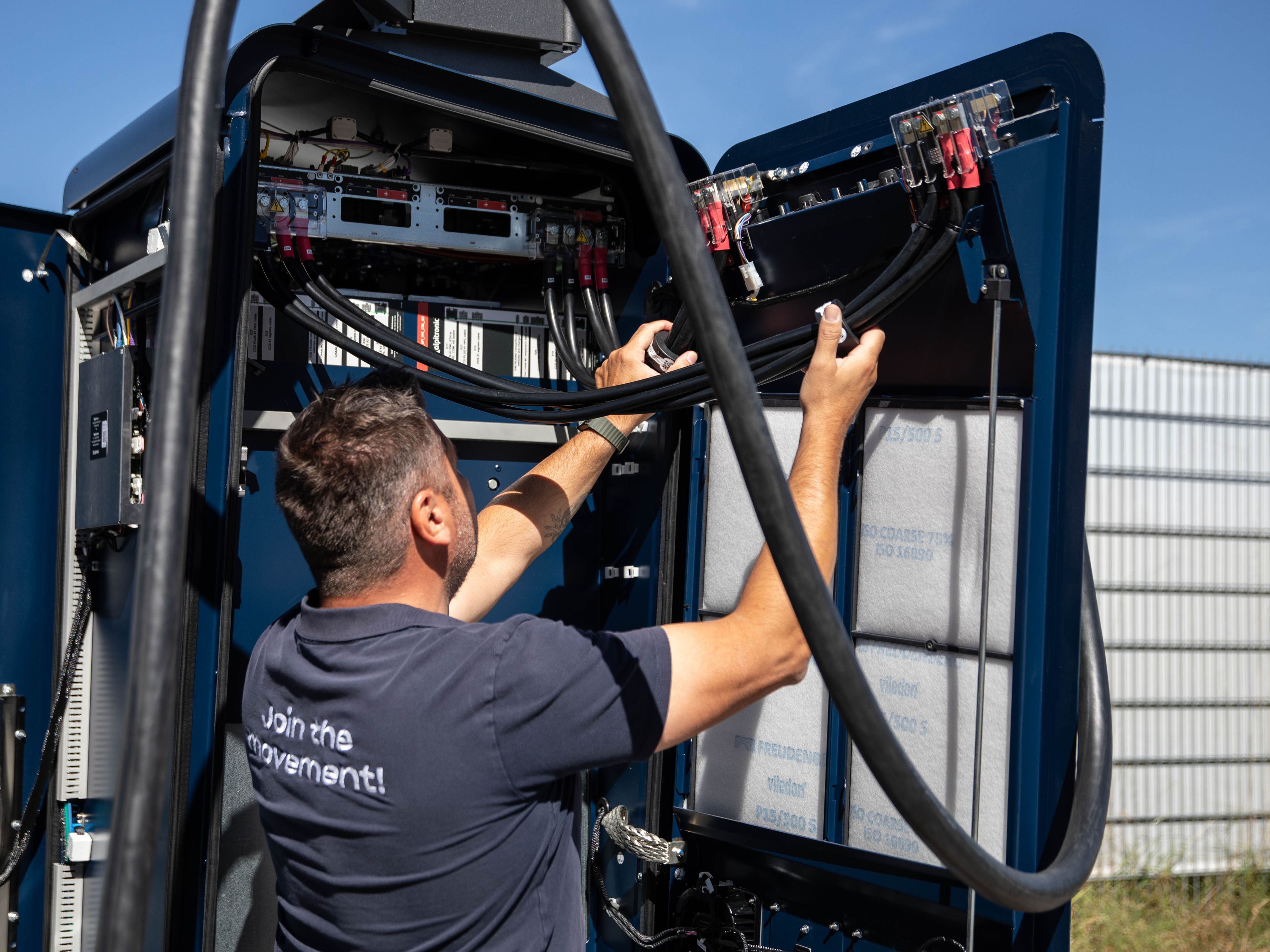a man working on the inner workings of a HYC 200-400 fast charging station
