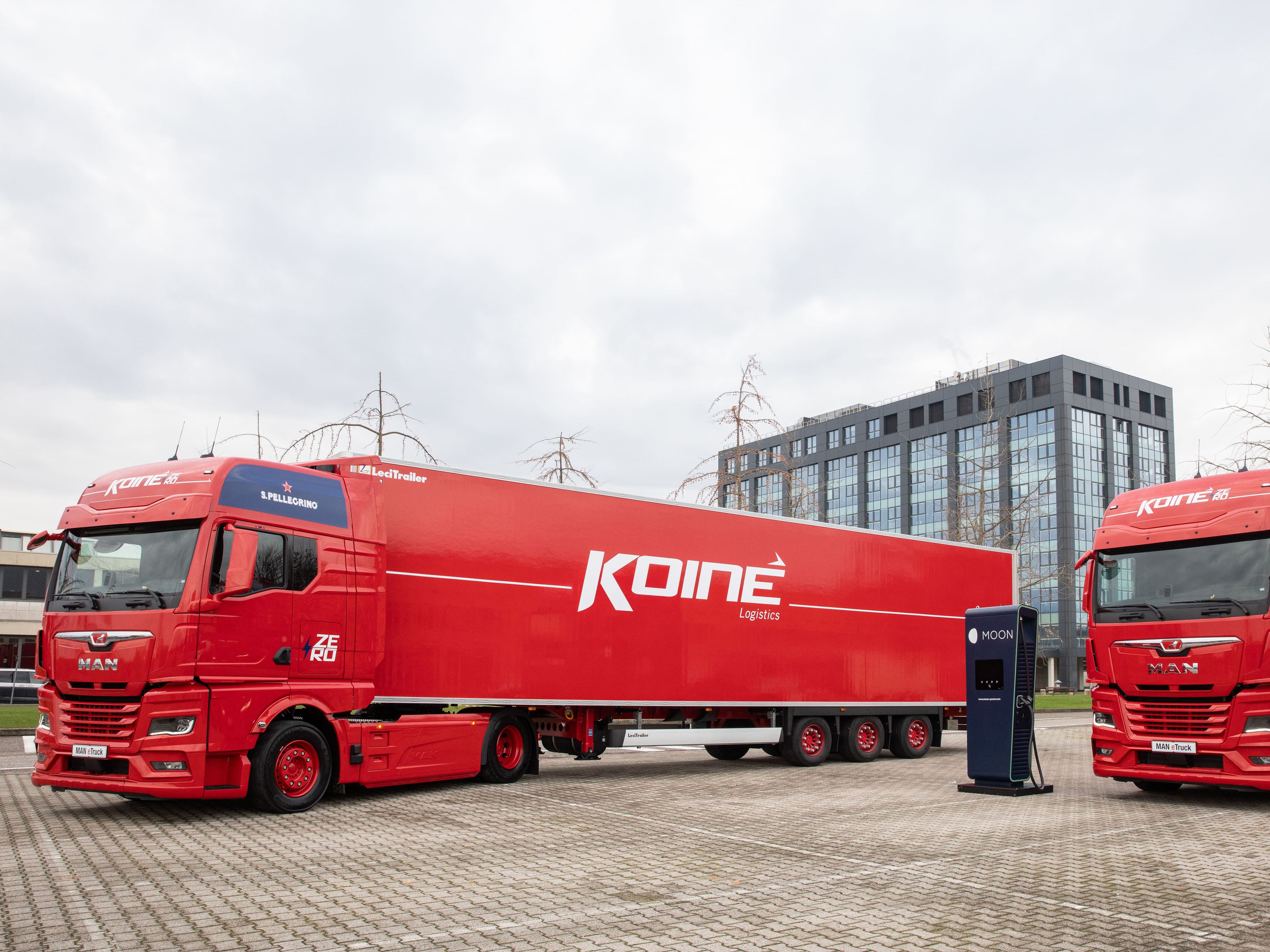 two Koiné trucks next to a POWER Charger HYC 400