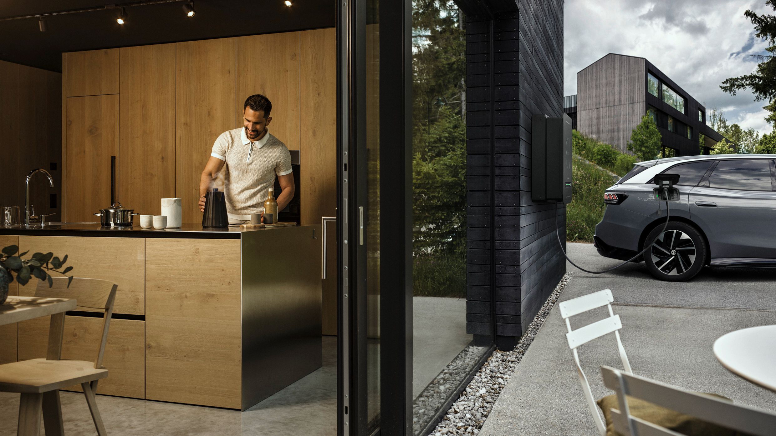 Man in kitchen while car powered by bidirectional wallbox house