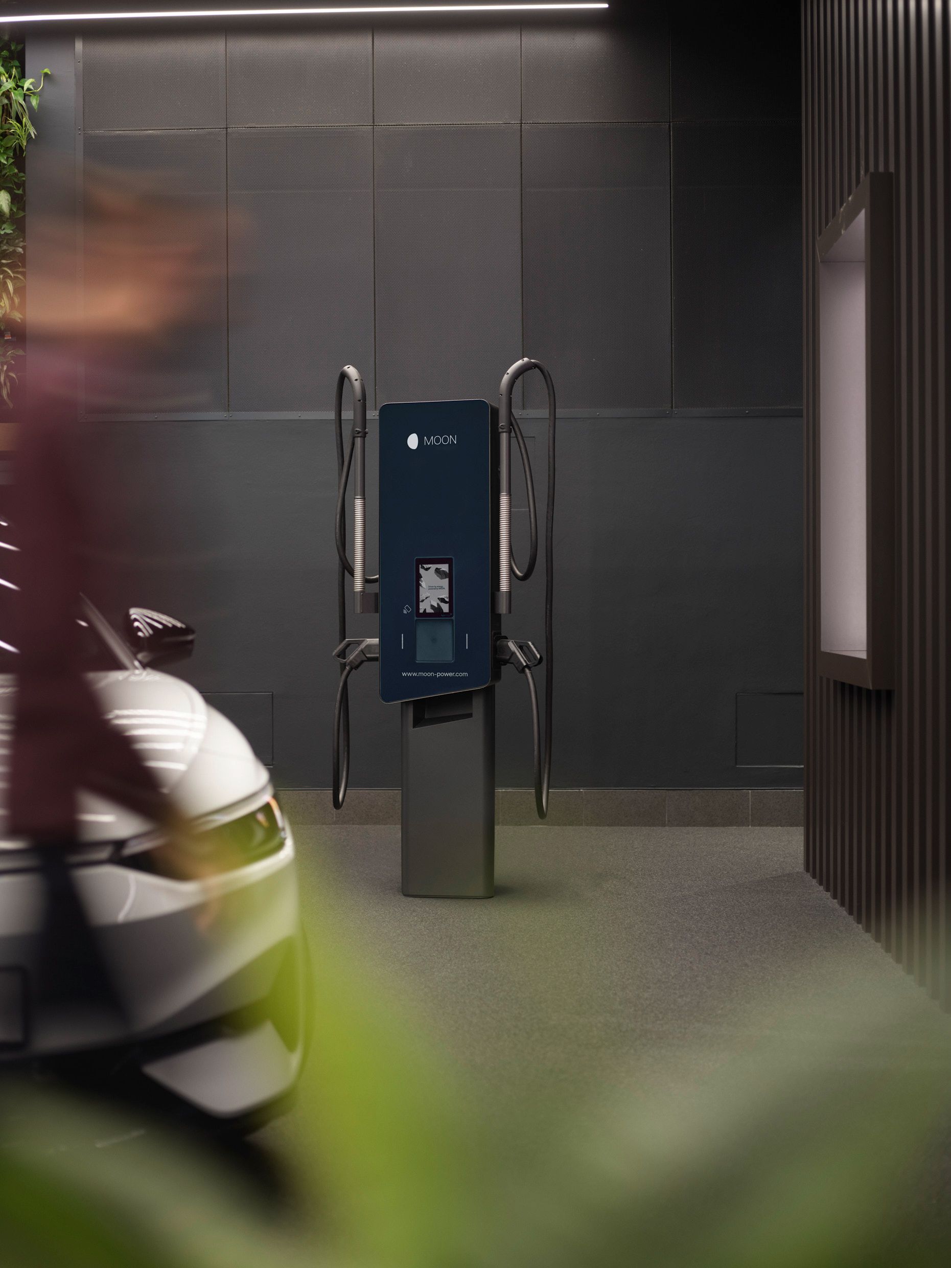 Wallbox in a room with gray walls and an electric car in the foreground