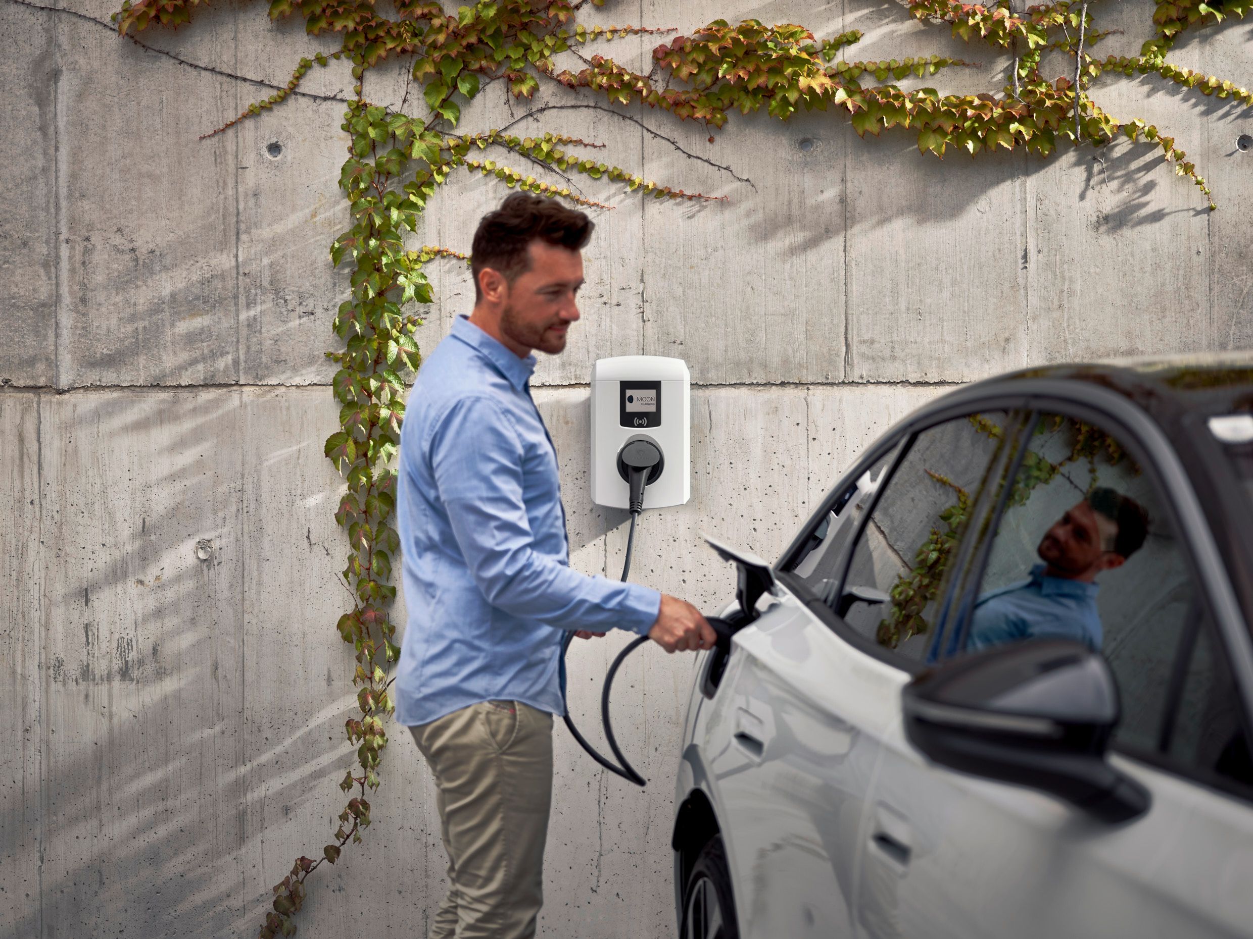 Man charging a car with a wallbox