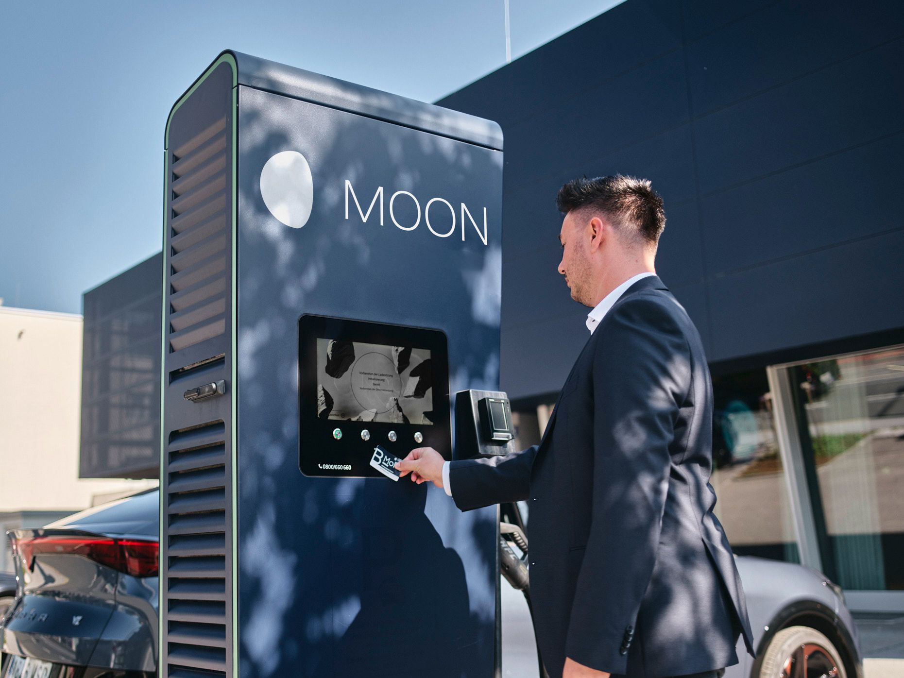 Man holds card to a fast charging station