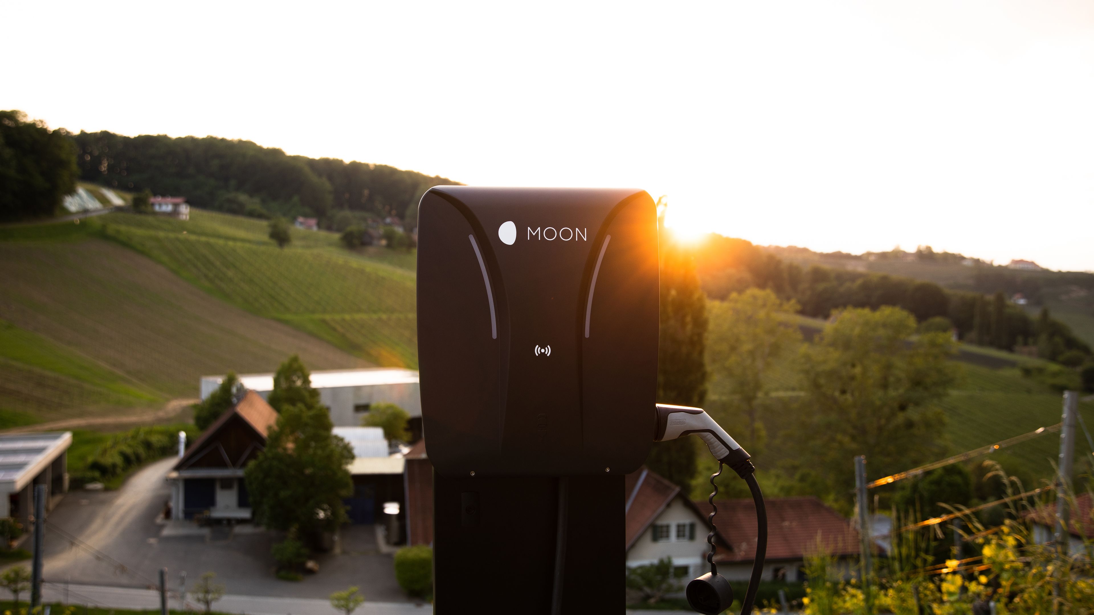 MOON-Ladestation vor Landschaft mit Sonne