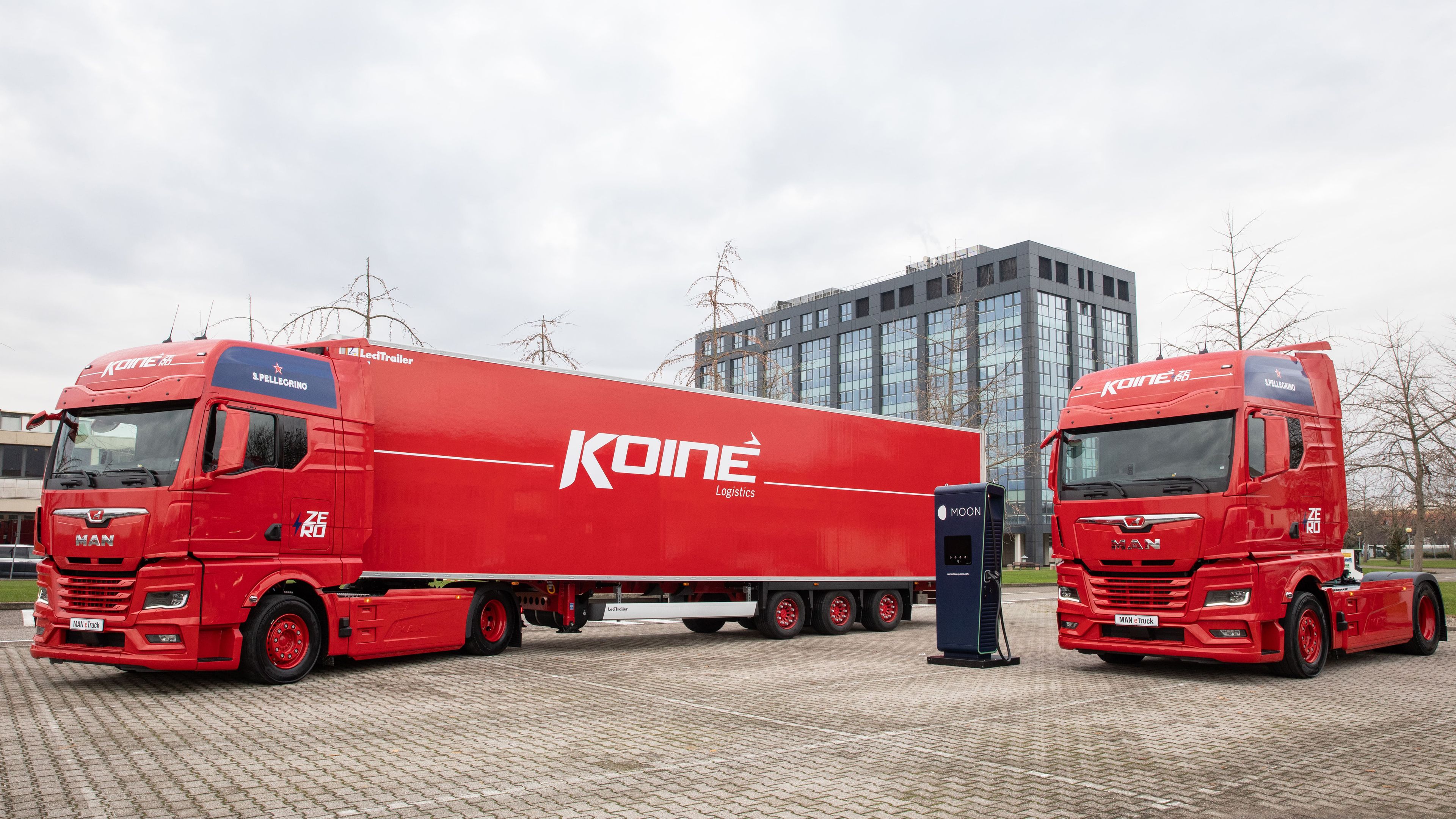 two Koiné trucks next to a POWER Charger HYC 400