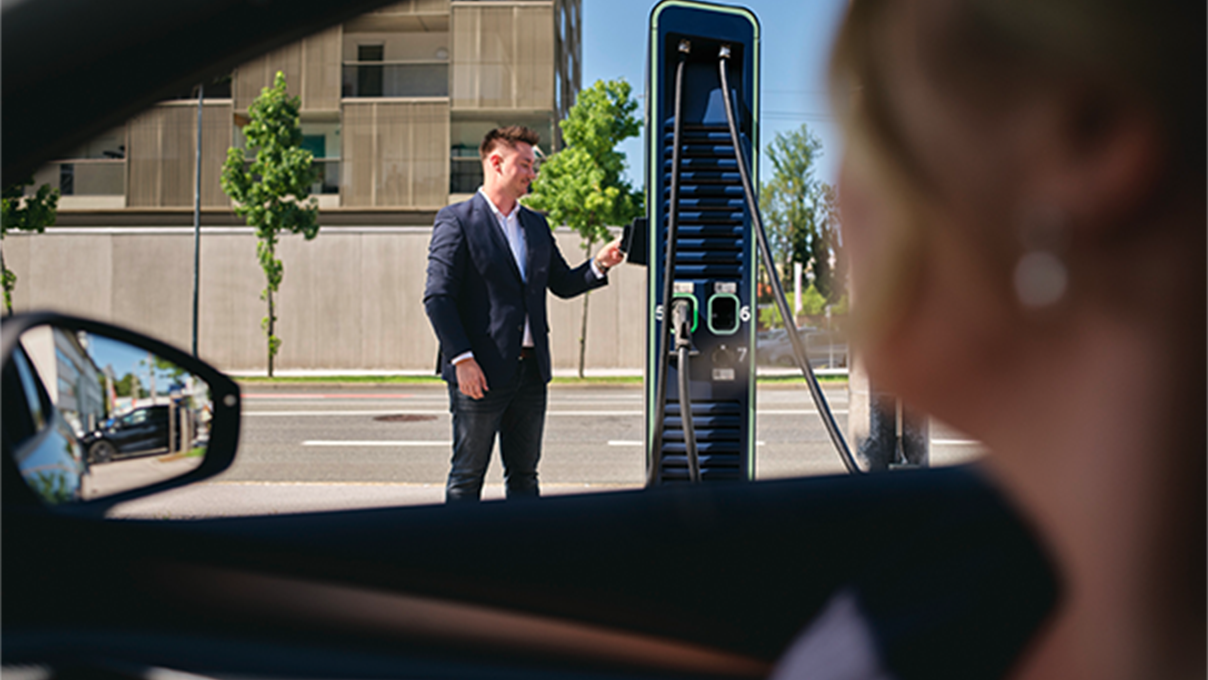 Man holds card to a fast charging station