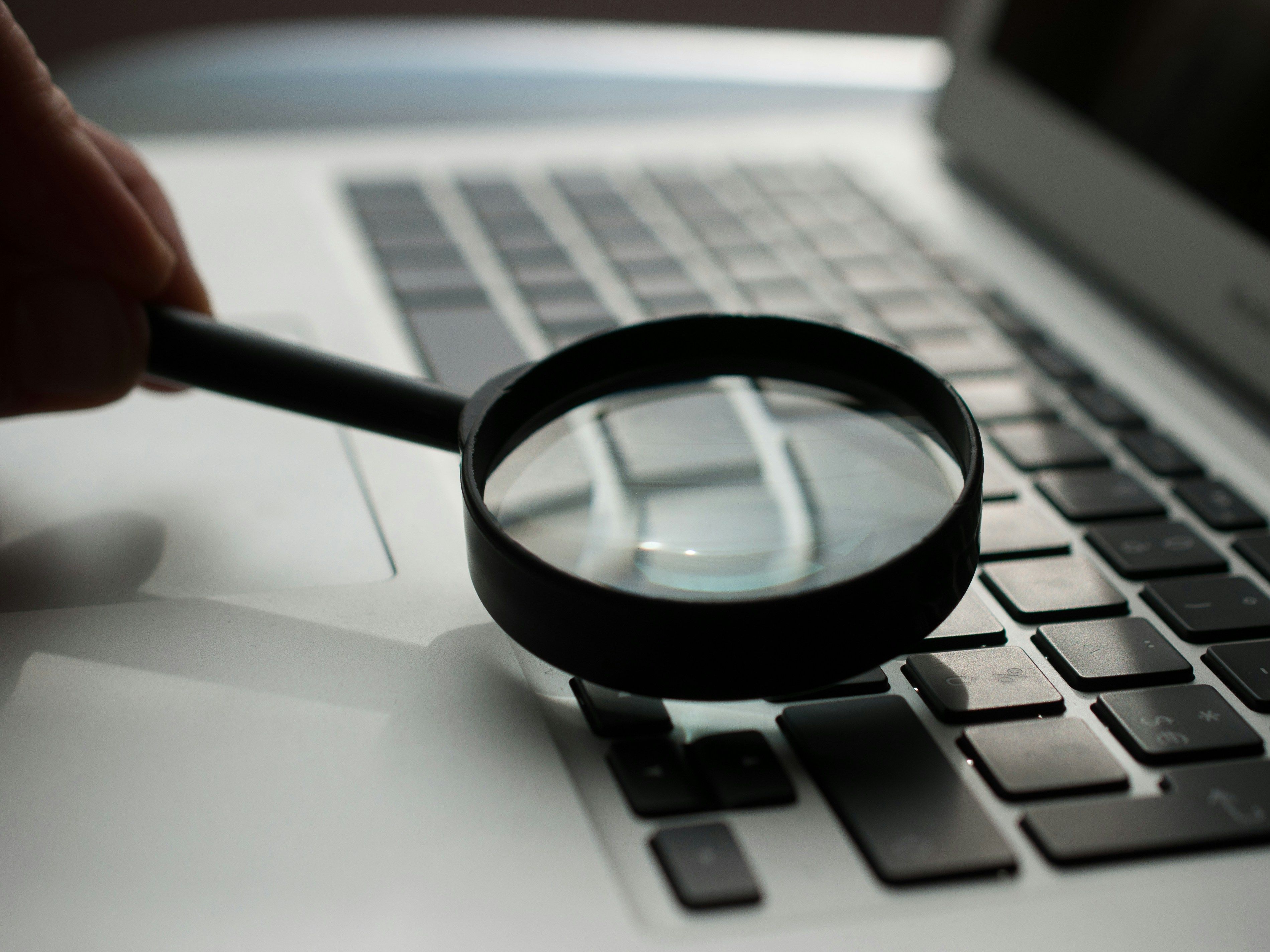 Magnifying glass over gray laptop