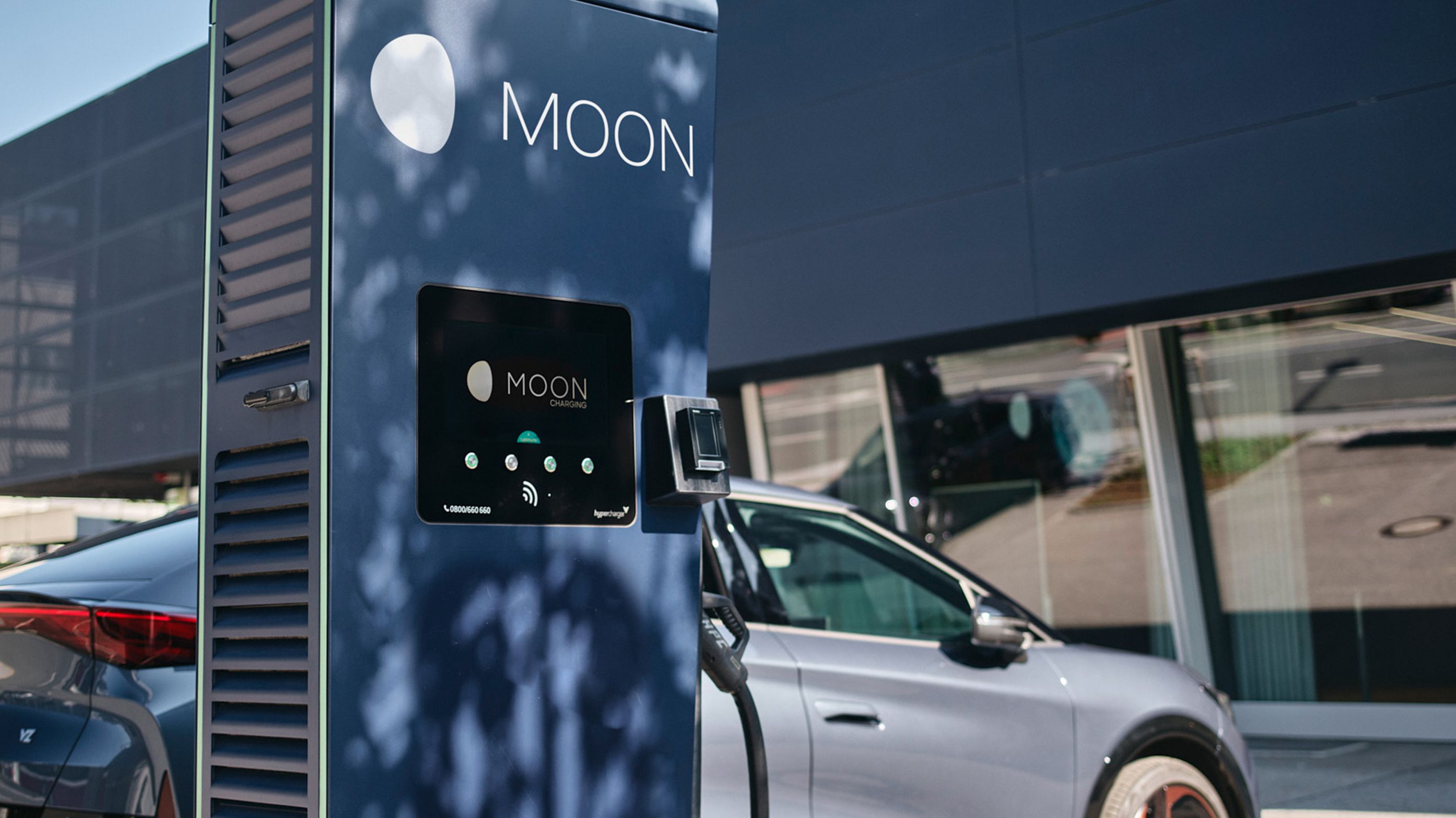 Fast charging station in front of an electric car with a display