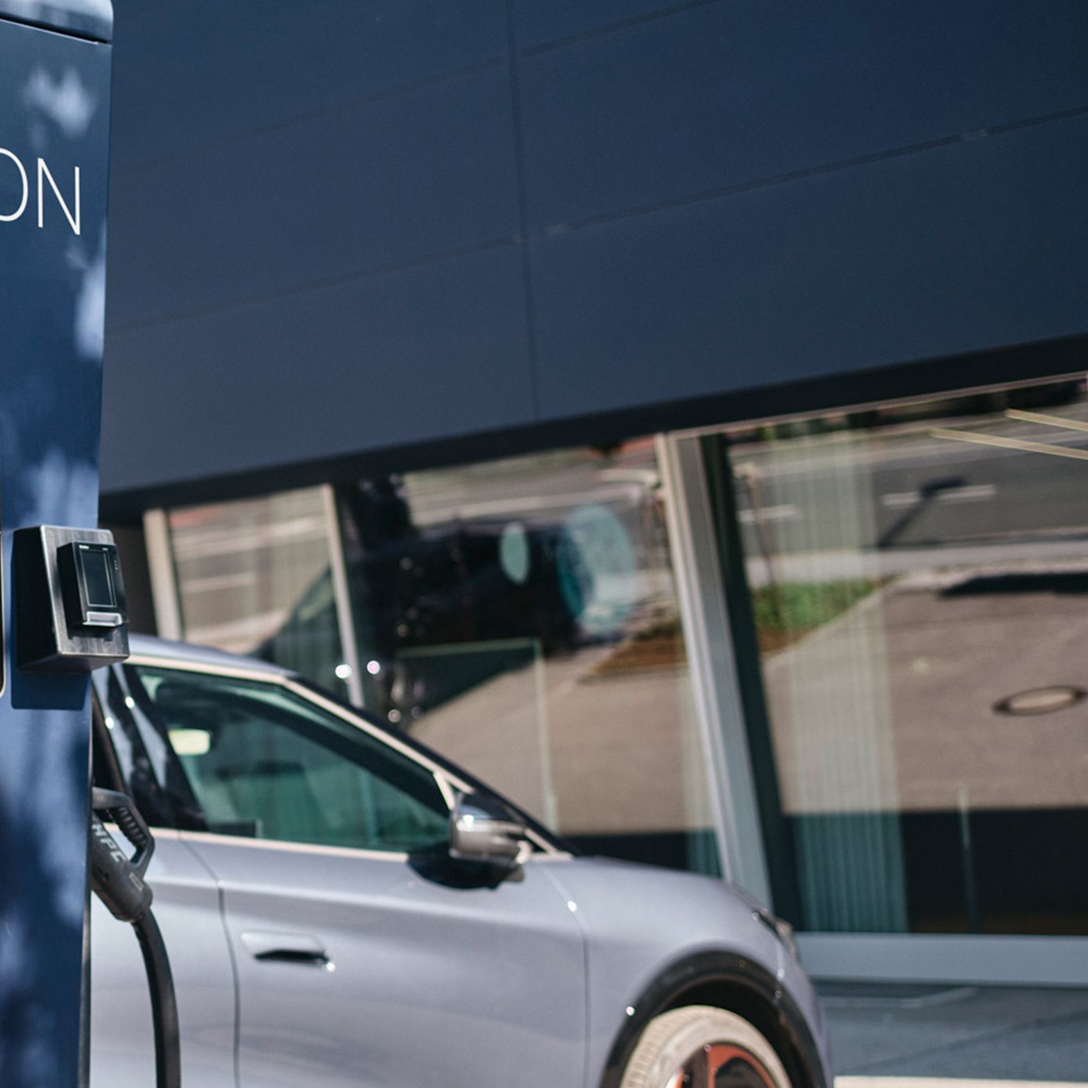 Fast charging station in front of an electric car with a display