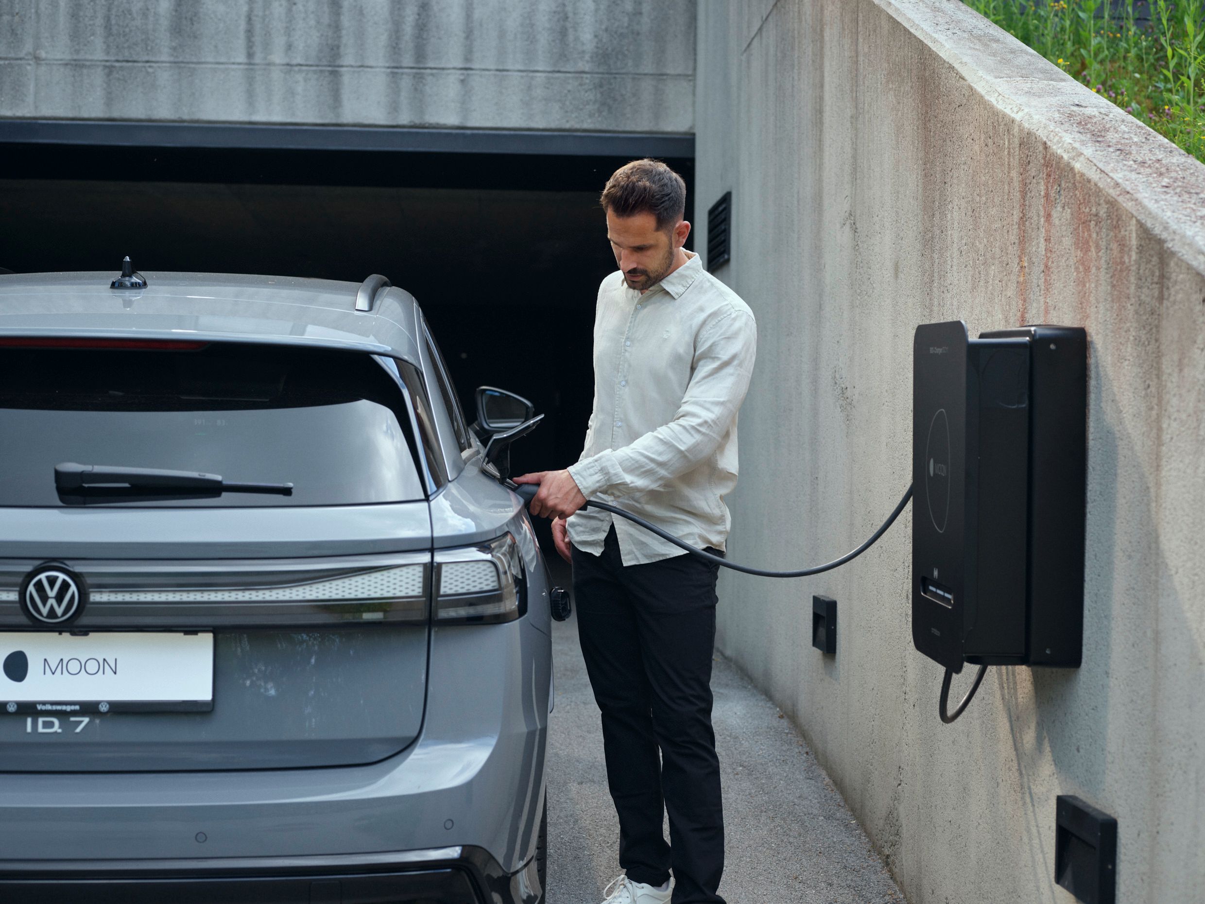 Man plugs car into bidirectional wallbox BiDi Charger 11 DC
