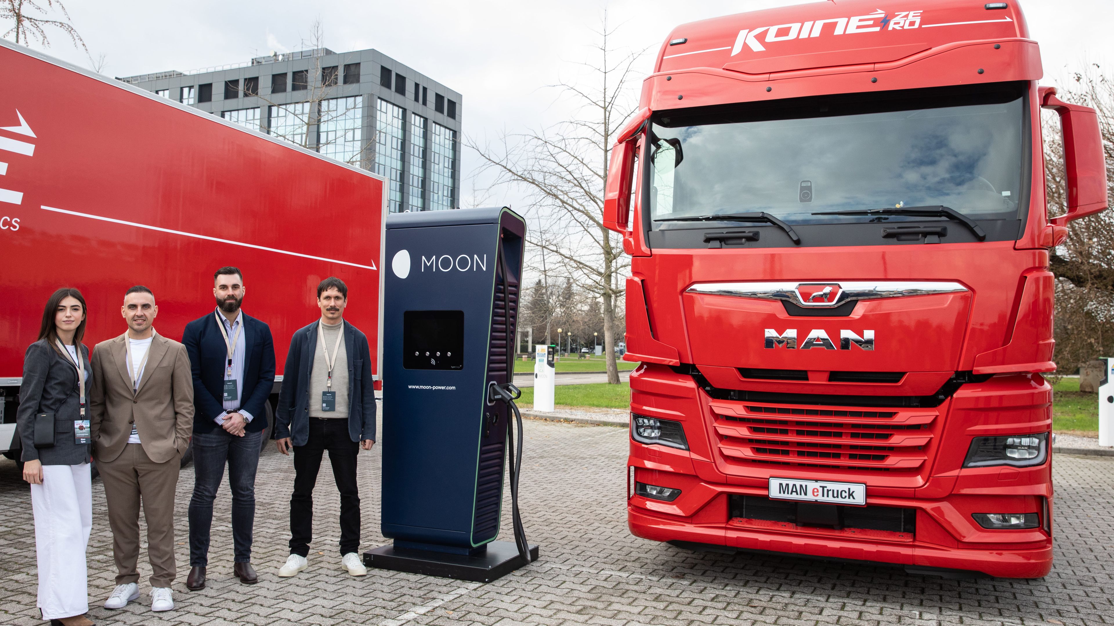 four people standing next to a POWER Charger HYC 400 and a Koiné truck