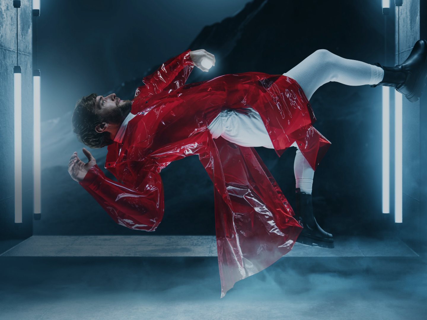 Man in zero-gravity,  dressed in red trench and surrounded by lights