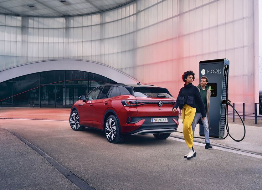 Red VW e-car charges at MOON's POWER Charger charging station