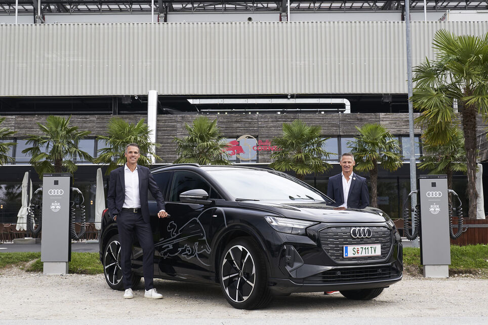 Thomas Beran and Stephan Reiter standing by an Audi and MOON´s power chargers